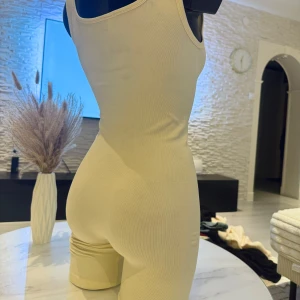 Beige ärmlös bodysuit - Snygg beige ärmlös bodysuit med en tight passform. Perfekt för en stilren och minimalistisk look. Tillverkad i ett mjukt och stretchigt material som formar sig efter kroppen. Passar perfekt som oversize modell (s/m/l storlek). Jag rekommenderar den varmt.🌸👌