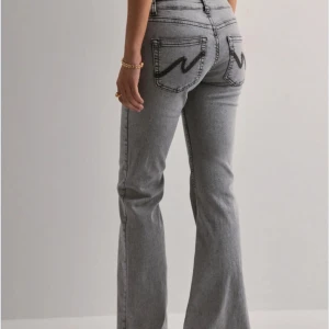 Low waist bootcut jeans - Säljer ett par gråa jeans från Nelly. Byxorna är i storlek 32 och är i nytt skick. Köpte byxorna för 700kr så säljer för 400kr