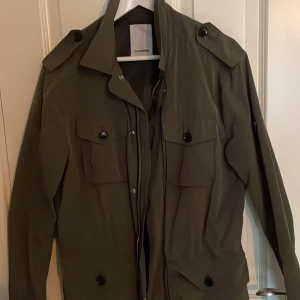 Field jacket - Säljer en tvär fet J.Lindberg fild jacket som är perfekt nu till våren och sommaren pågrund av att den är så tunn, skick 10/10 har inte använt den alls så mycket.  Om ni har några frågor är det bara o höra av sig🤙🔥