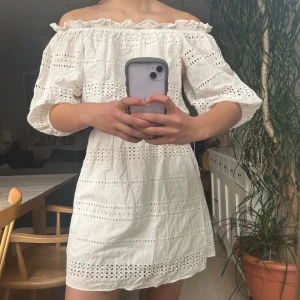 Vit klänning till studenten - Superfin vit offshoulder klänning med spetsdetaljer och trekvartsärmar. Från twist and tango. Perfekt för studenten och inför sommaren. Elastisk vid midjan, axlarna och ärmarna. Använd fåtal gånger och i bra skick. Storlek 34, xs, men passar även s. (Är 170cm). Material:100% bomull.