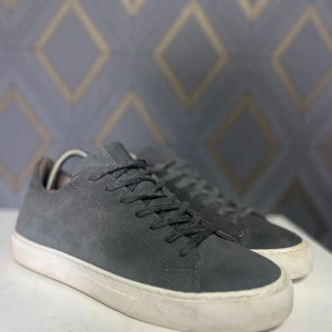 Grå sneakers från björn Borg  - Snygga grå sneakers i mocka ifrån Björn Borg med vit sula och klassisk snörning. Perfekta för en stilren look.