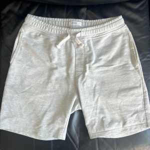 Grå shorts från Burton Menswear London - Säljer ett par grå shorts från Burton Menswear London. De har en elastisk midja med snörning för justerbar passform. Perfekta för en avslappnad stil.
