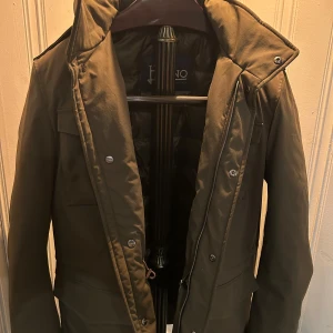 Herno Jacka - Snygg Olivgrön Herno Field Jacket som är perfekt nu inför våren. Storlek 48 vilket motsvarar M/L. 