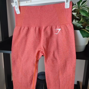 Orangea Gymshark Leggings i storlek XS - Orangea leggings från märket Gymshark. Storlek XS. Helt nya utan lapp. Intakta loggor. Superfina! Lätt countor i form av prickar runt rumpan och fram på sidorna på leggingsen.
