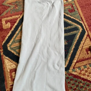 Grå långkjol från Zara - Säljer en stilren grå långkjol från Zara. Kjolen har en enkel design och är perfekt för en minimalistisk look. Tillverkad i ett mjukt och bekvämt material som ger en skön passform.