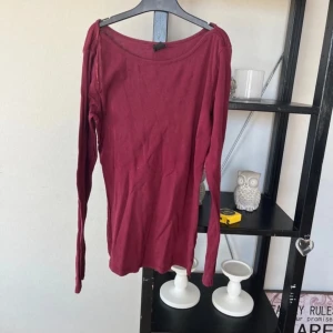 Vinröd långärmad topp - Säljer en vinröd långärmad topp med en enkel design. Perfekt för höst och vinter. Toppen har en rund hals och är tillverkad i ett mjukt material.