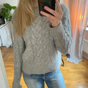Grå stickad tröja från Gina Tricot - Säljer en mysig grå stickad tröja från Gina Tricot med flätmönster💕. Tröjan är nästan aldrig använd och är i superbra skick. Storleken är 146/152 men passar som XS-S 💓