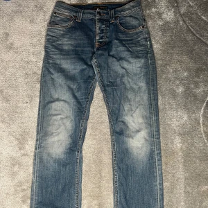 Blå jeans från Nudie Jeans - Längd 100 Midja 41Cm Skick 6/10!Säljer ett par snygga blå jeans från Nudie Jeans. De har en klassisk femficksdesign med slitna detaljer och en bekväm passform. Har en unik design vid botten av jeansen! Priset kan förhandlas!