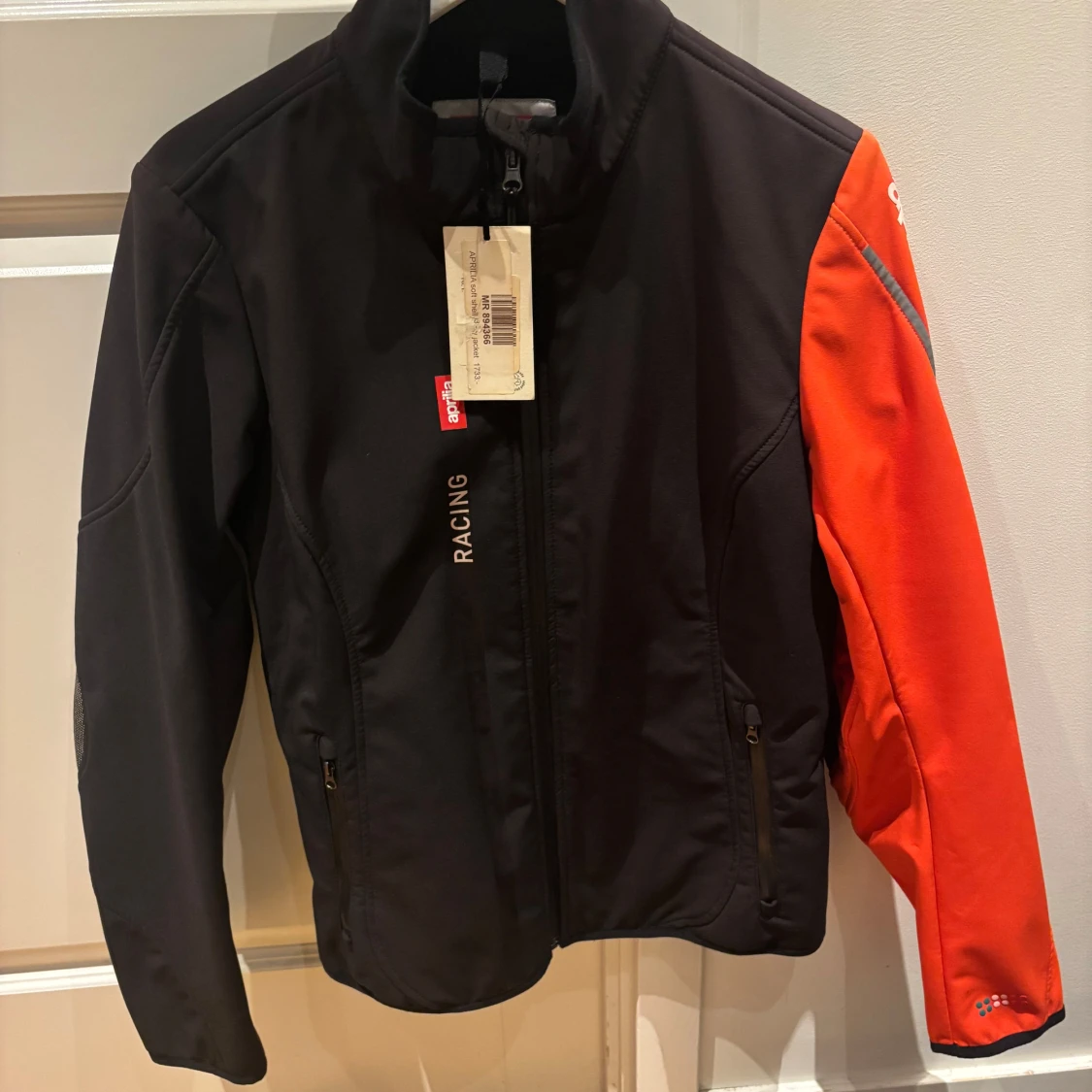 Svart och orange racingjacka från Aprilia