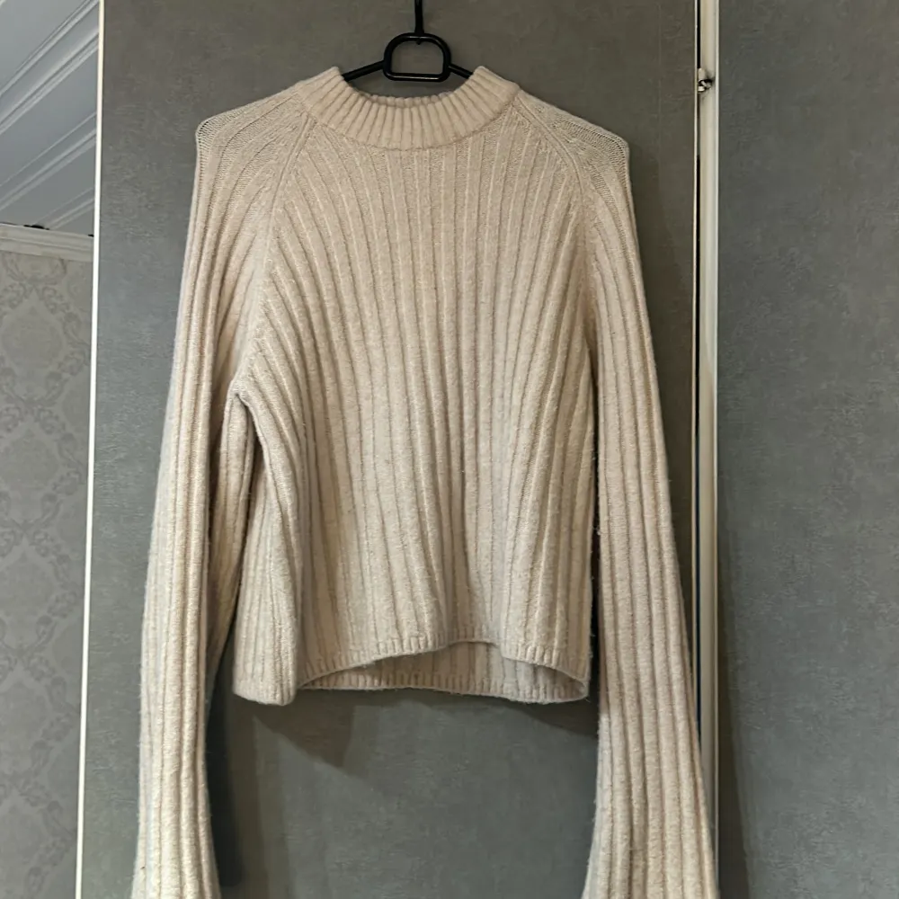 Säljer en mysig beige stickad tröja med ribbad struktur. Tröjan har långa ärmar.. Neuleet.