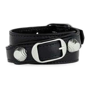 Svart Balenciaga armband  - (Kan gå ner några hundra i pris vid snabb affär) Elegant svart armband från Balenciaga med silverdetaljer. Armbandet har en stilren design med ett justerbart band och en dekorativ spänne i silver. Perfekt för att ge en lyxig touch till din outfit. (Priset är diskutabelt)