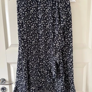 Blommig kjol från ONLY - Snygg blommig volangkjol från Only i storlek S. Längden från midjan till botten är 72cm. Midjemått rakt över är 33cm men han en töjbar midja.