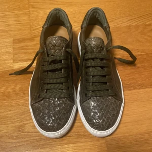 Mörkgröna kalvskinnssneakers – handgjorda i Italien - Säljer ett par mörkgröna sneakers i kalvskinn med matchande snörning och vit kontrastsula. Handgjorda i Italien och köpta på CC Shoes i Sturegallerian. Perfekta för en stilren och uppklädd vardagslook. Använd 1 gång. Storlek 40 ½, men passar även 41. Nypris: 4500 kr Mitt pris: 1000kr