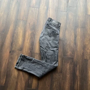 Grå grover jeans från Replay - Snygga grå jeans från Replay med klassisk femficksdesign. De har en rak passform och är perfekta för en stilren look. Tillverkade i ett slitstarkt material som ger en bekväm känsla hela dagen.