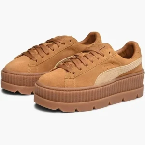 Bruna sneakers från Puma - Snygga bruna sneakers från Puma med en hög platåsula och klassisk snörning. Skorna är tillverkade i mocka och har en stilren design med Pumas ikoniska rand på sidan.