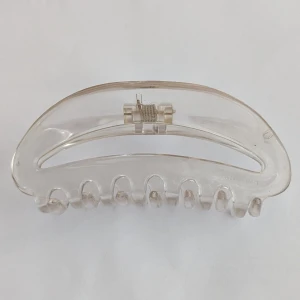 Transparent hårklämma - Säljer en stilren och transparent hårklämma i plast. Perfekt för att enkelt sätta upp håret med stil. Klämman har en klassisk design med en stark fjäder för bra grepp.