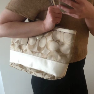 Coach väska  - Superfin äkta vintage Coachväska i beige canvas. Väldigt fint skick! Köpt på Vestiare Collective! Storlek medium. 