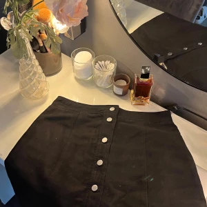 Svart kjol med knappar från HM - Snygg svart kortkjol från HM med silverfärgade knappar framtill. Jättefint skick!! Säljer för att den tyvärr är för liten på mig därav har jag ingen bild med den på💌