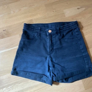 Svarta shorts från &Denim - Snygga svarta shorts från &Denim i en klassisk design. De har en knapp och dragkedja framtill samt fickor både fram och bak. Perfekta för en stilren look.
