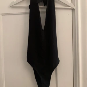Svart body från Zara - Svart body med öppen rygg och knytning i nacken! Prislappen kvar! 