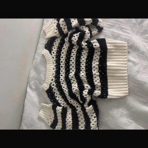 Randig stickad tröja i svart och vit från Gina tricot  - Säljer en mysig stickad tröja med svart och vit randigt mönster. Tröjan har långa ärmar och ribbade muddar vid ärmslut och nederkant. Perfekt för kyliga dagar! 