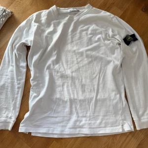 Stone Island vit tröja - Säljer en stilren vit tröja från Stone Island. Tröjan är i bra skick men tecken på användning finns. Patch i bra skick. Strl XL men sitter mer som L enligt mig. Sitter löst på mig som vanligtvis bär M. QR kod finns. Säljer då den inte riktigt är min stil längre. 