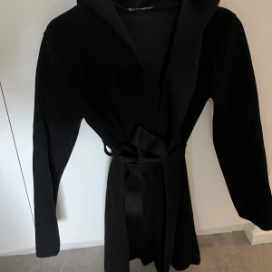 Svart kappa - Säljer en jätte fin kappa i färgen svart , perfekt till hösten. Den har även luva med för fler bilder är de bara att höra av sig. Frakten står köparen för.