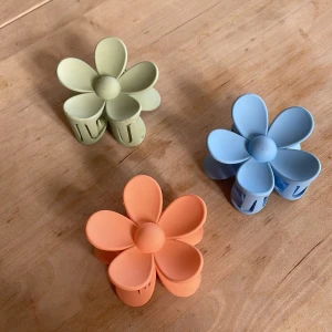 Blomformade hårklämmor💗 - Säljer tre söta blomformade hårklämmor i pastellfärger: ljusblå, ljusgrön och aprikos💗 Perfekta för att ge en färgglad touch till din frisyr. Klämmorna har en mjuk och rundad design som liknar blommblad, perfekt nu till våren och sommaren!🌸☀️90 kr för all 3🫶