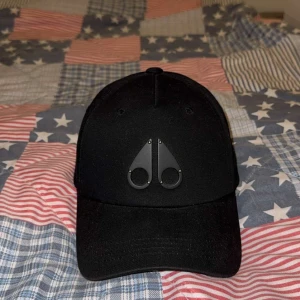 Svart keps med logotyp - Snygg svart keps med en stilren logotyp framtill. Kepsen har en justerbar rem baktill för perfekt passform. Perfekt för en casual look.