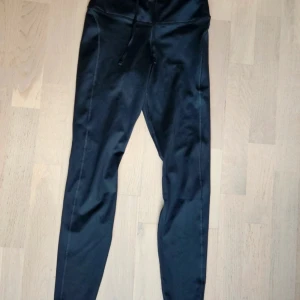 Nike löpartights  - Svarta löpartights från Nike. Använda en gång, är i mycket fint skick. Storlek XS. Har sidoficka och mobilficka baktill. Meshtyg baktill på benen.