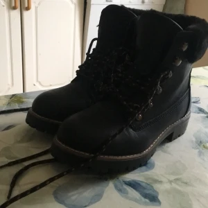 Svarta kängor med snörning - Säljer ett par svarta kängor från Linear med snörning och pälsfoder. De har en robust sula och metallöglor för snörena. Perfekta för kyligare väder. Skorna är aldrig använda då de är köpte små.