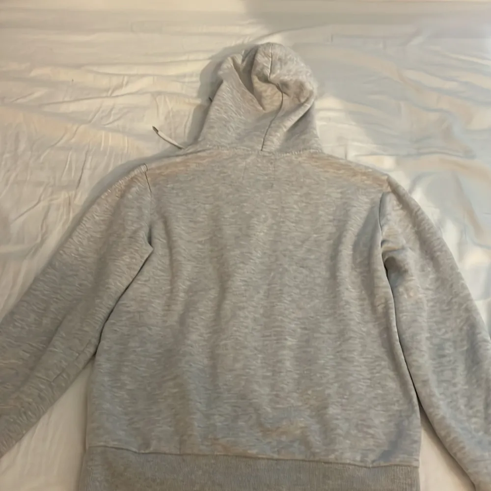 Säljer en stilren grå hoodie från 157 i storlek S. Den har en dragkedja framtill och en praktisk huva med snören. Perfekt för en avslappnad look.. Neuletakit & Villapaidat.