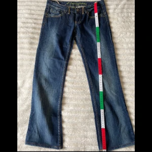 Blå lågmidjade bootcut jeans - Snygga blå bootcut jeans med broderade detaljer på bakfickorna. Jag är 163 cm. Säljer då de är för korta så passar bra till den som är lite kortare. Innerbenlängden är ca 69 cm. Köparen står för frakten 💕