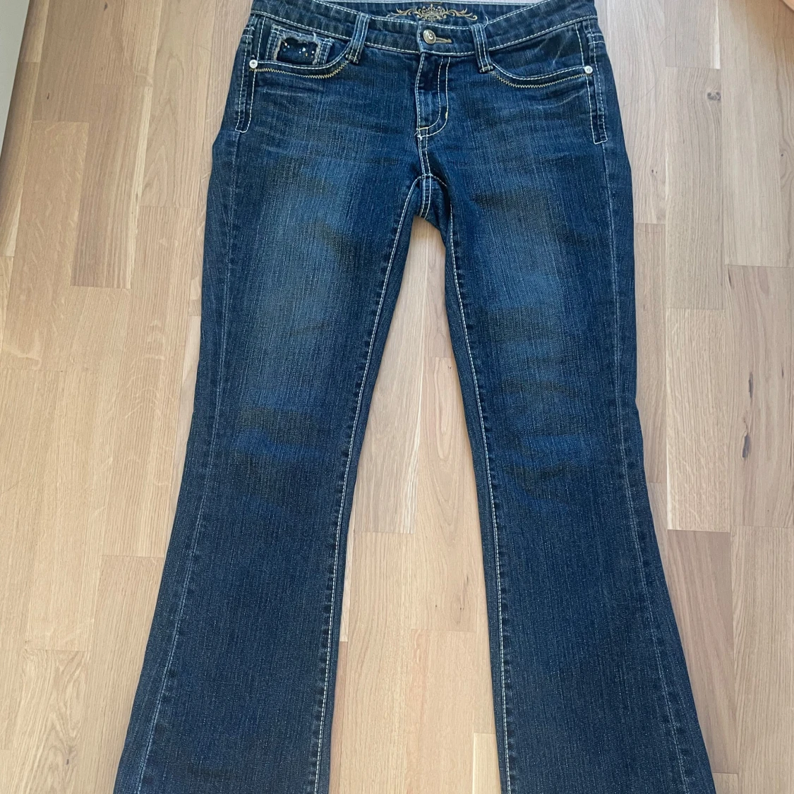Blå bootcut jeans med broderade fickor