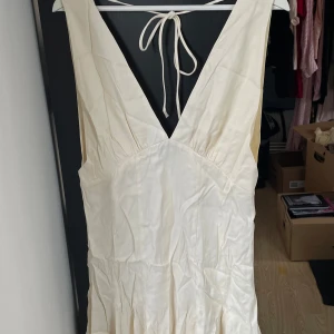 Vit klänning i Marilyn Monroe-stil, H&M - Superfin vit klänning från H&M i storlek M. Klänningen har djup v-ringning, knytband i ryggen och är ärmlös. Den är tillverkad i ett glansigt material som ger en lyxig känsla med bra tyngd och fall, och har en lätt utsvängd kjol. Perfekt för sommarens alla tillfällen! Nyskick med tag kvar. 