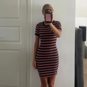 Tighta klänningar  - Säljer två tighta kortklänningar från H&M stretchigt material. Den ena är svart med röda, vita horisontella ränder, den andra är helsvart med gula och vita ränder längs sidorna. Båda har rund hals och korta ärmar. Styck pris 100kr, 200kr tillsammans 🌺