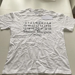 Maison Margiela T-shirt - Vit t-shirt från Maison Margiela. Storlek M, passar någon som är mellan 180-185 ungefär. Priset går att diskutera. Bara höra av dig vid intresse!
