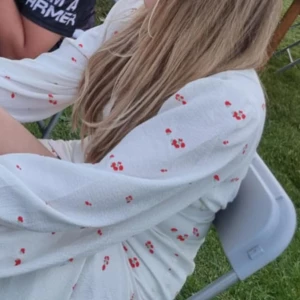 Vit kortklänning med röda blommor - Superfin vit kortklänning med små röda blommor och långa ärmar. Klänningen har en lätt v-ringning och markerad midja som ger en snygg siluett. Perfekt för sommarens alla tillfällen och ger en fräsch och söt look. Kom privat för fler bilder, klänningen är en adoore i kort modell. Så fin och endast använd 1 gång❣️