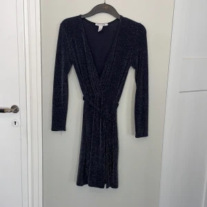 Glitter omlott klänning från nelly - Omlottklönning med snörning och glitter. Stretchig. Supeffin! Lite snvönt skick-se alla bilder