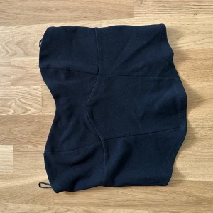 Svart korsett-topp från Gina Tricot - Säljer en svart korsett-topp från Gina Tricot i storlek M. Toppen är axelbandslös och har en figurnära passform med markerade sömmar och dragkedja i sidan. Perfekt att styla med jeans eller kjol för en trendig look.