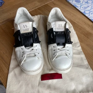 Valentino Rockstud sneakers vit/svart stl 37 - Snygga Valentino Rockstud sneakers i vitt skinn med svart läderdetalj och svarta nitar över vristen. Mkt fint skick! Dustbag medföljer 