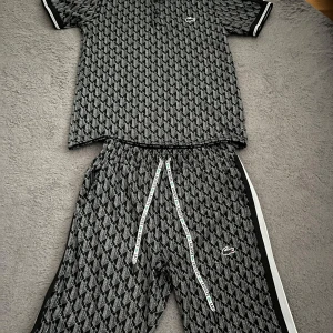 Lacoste monogram set  - Säljer ett set från Lacoste med grått geometriskt mönster, vita och svarta sidoremsor och snörning i midjan med Lacoste-logga. 