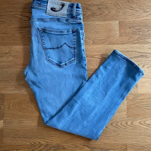 Ljusblå jeansbyxor Style 622 - Säljer ett par ljusblå jeansbyxor från Jacob Cohen i modellen 622. Storlek W33, bredd 42 cm, längd 88 cm