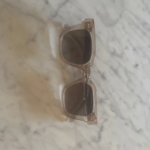 Beige CHIMI solglasögon i fyrkantig modell - Snygga solglasögon från CHIMI i modellen ECRU 04. Använda ett fåtal gånger och har inga defekter eller så. Jag säljer för att jag har ett par andra och därför kommer dessa inte till användning. Köpta för 1 400 kr.