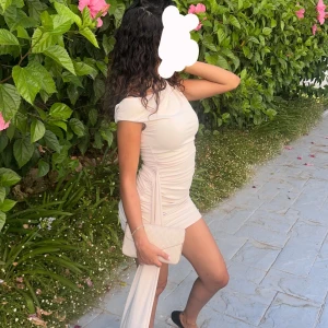 Ljusbeige offshoulder kortklänning - Supersnygg ljusbeige kortklänning med offshoulder och draperad effekt på sidan. . Perfekt för dig som vill sticka ut med en trendig och elegant look. Bra skicks endast använd en gång