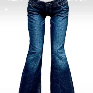 Blå bootcut jeans med låg midja - Snygga blå jeans med bootcut-modell och låg midja. Klassisk femficksdesign och cool denimlook som passar perfekt till sneakers eller boots. Jeansen har en markerad utsvängning nedtill och tydliga sömmar.
