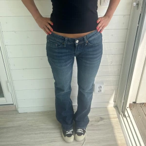 Blå bootcut jeans - Snygga mörkblå bootcutjeans i storlek W27. Midja rakt över: 38,5 cm innerbenslängd: 82 cm. Jeansen är även stretchiga 