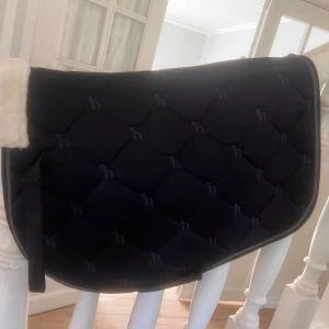 Horze Pony/VS - Snygg och bekväm sadelpad från Horze i storlek Pony/VS. Perfekt för dig som rider och vill ge din häst extra komfort. Mjuk vaddering och stilren design gör den både praktisk och snygg i stallet. Och aldrig använd.