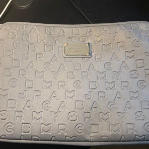Grå datorfodral Marc by Marc Jacobs - Grå datorfodral från Marc by Marc Jacobs. Skit snyggt nu till skolstarten!Täcken på användning men fortfarande fin! Några defekter (se bild), men dragkedjan funkar perfekt! Måtten 35x25 (chromebook skoldator).Pris kan diskuteras!!! 
