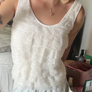 Vit spetsig linnetopp st S - Supersöt vit linnetopp med spetsdetaljer framtill och slät baksida. Toppen är ärmlös och har rundad halsringning. Perfekt för dig som gillar romantiska vibes och vill ha något luftigt och lätt till sommaren. På sista bilden försöker jag visa två super små hål som knappt syns men känner att jag nämner det ändå! Ingen man tänker på om man inte kollar supernoga! Suttit en rosett där innan som jag var tvungen att ta väck 🤭🤭